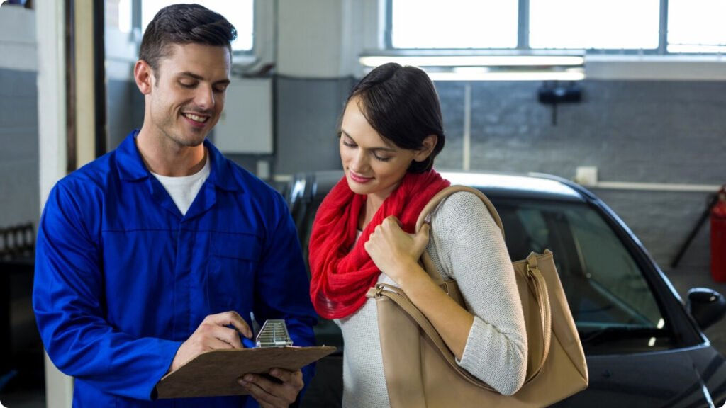 Mechanic presenting cost of paintless dent removal to customer